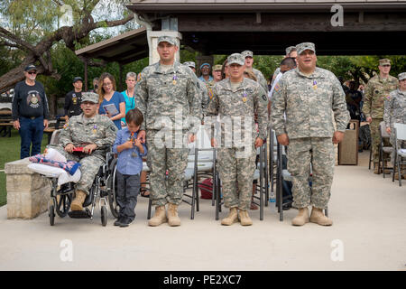 Texas cuore viola i destinatari, a sinistra e a destra, SPC. Jose Romo, SPC. James Burkett, Sgt. Michael Cantu e Staff Sgt. Guadalupe Chapa stand a cantare "Canzone dell'Esercito" in occasione di una cerimonia di premiazione che si terrà a Fort Sam Houston a San Antonio, Sett. 24, 2015. Texas Gov. Greg Abbott ha presentato il Texas viola i cuori alla guardie, che ha ricevuto le loro ferite mentre implementata con il 1° Stormo, 112reggimento di cavalleria, che è stato parte della forza multinazionale e osservatori (MFO) missione in Egitto. (U.S. Esercito nazionale Guard foto di Sgt. 1. Classe Malcolm McClendon) Foto Stock