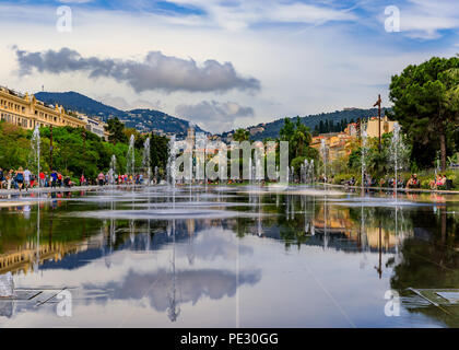 Nizza, Francia - 24 Maggio 2018: riflettendo fontana sulla Promenade du Paillon, circondato da splendidi edifici storici e verde parco urbano a Place Mas Foto Stock