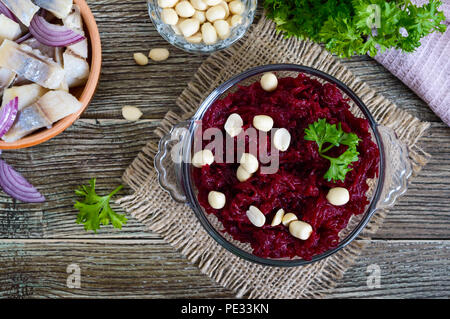 Insalata dal bollito di bietole, pezzi di aringhe con la cipolla rossa, i dadi. Vista dall'alto. Foto Stock