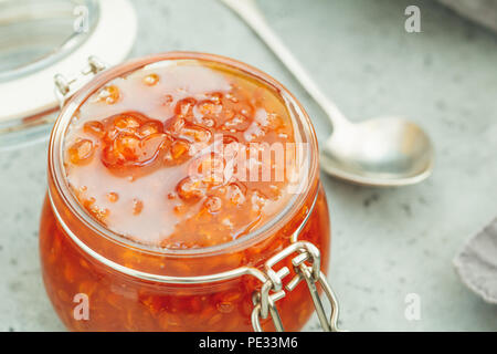 Vaso di vetro con cloudberry inceppamento. Cucina nordica. Foto Stock