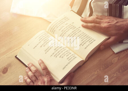 Uomo ebraico mani un libro di preghiere, pregando accanto al tallit. Jewish simboli tradizionali. Rosh hashanah (ebreo nuovo anno di vacanza), Shabbat e Yom Foto Stock