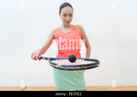 Close-up di una gomma pallina cava sulla nuova racchetta da squash di montare donna Foto Stock