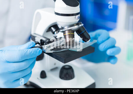 Dispositivo moderno. Messa a fuoco selettiva di dettaglio di un moderno microscopio in piedi in laboratorio mentre vengono utilizzati per la ricerca scientifica Foto Stock