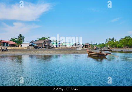 Il tragitto in traghetto attraverso il fiume Kangy al piccolo villaggio di pescatori con vecchie case in legno, barche da pesca e da alte palme, Chaung Tha, Myanmar. Foto Stock