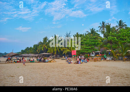 CHAUNG THA, MYANMAR - 28 febbraio 2018: la gente del posto e i turisti del piacevole spiaggia di sabbia con lussureggianti palme ombrose, il 28 febbraio a Chaung Tha. Foto Stock