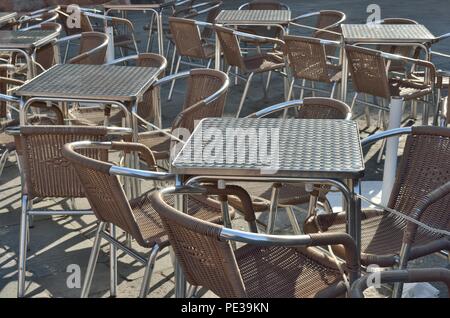 Una bella composizione di un gruppo di tavolini e sedie a forma quadrata, non occupato, a San Marcos - Piazza San Marco, Venezia, Italia, Europa Foto Stock