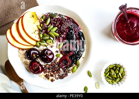 Durante la notte le OAT con Cherry,Nero burro di sesamo,bacche Frutta sciroppata,Chia di semi di cacao e le mandorle decorticate Foto Stock