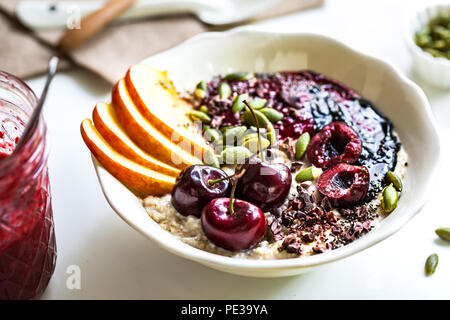 Durante la notte le OAT con Cherry,Nero burro di sesamo,bacche Frutta sciroppata,Chia di semi di cacao e le mandorle decorticate Foto Stock