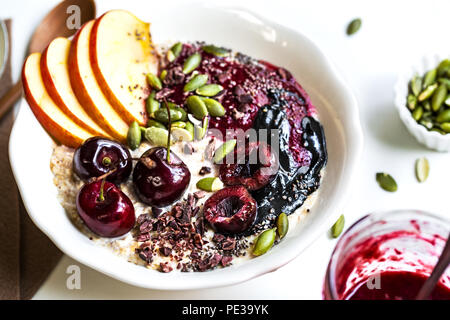 Durante la notte le OAT con Cherry,Nero burro di sesamo,bacche Frutta sciroppata,Chia di semi di cacao e le mandorle decorticate Foto Stock