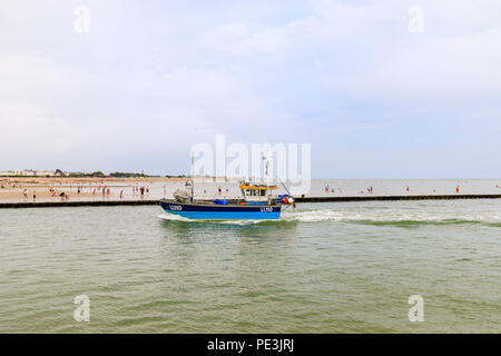 Un piccolo blu barca da pesca restituisce immettendo il fiume Arun estuario a West Beach, Littlehampton, south coast resort per vacanze in West Sussex in estate Foto Stock