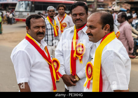 Mellahalli, Karnataka, India - 1 Novembre 2013: Karnataka Rajyotsava Parade. Tre funzionari politici con wite camicie e il giallo e il rosso membro Foto Stock