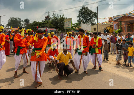 Mellahalli, Karnataka, India - 1 Novembre 2013: Karnataka Rajyotsava Parade. Gruppo di arancio e bianco ballerini e acrobati predisposizione per eseguire in st Foto Stock