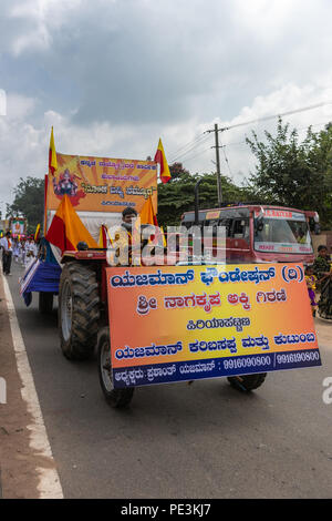 Mellahalli, Karnataka, India - 1 Novembre 2013: Karnataka Rajyotsava Parade. Trattore agricolo con grandi banner contenente Sree Nagakrishna mulino di farina. Ho Foto Stock
