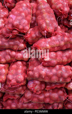 Sacs contenente cipolla grande impilati per la vendita al mercato locale a Little India, Singapore Foto Stock