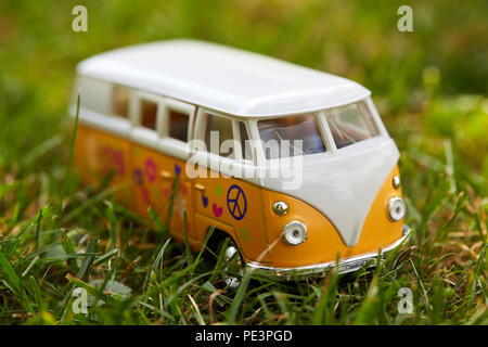 Orange bus VW toy figurine con hippie registri in geen gras Foto Stock