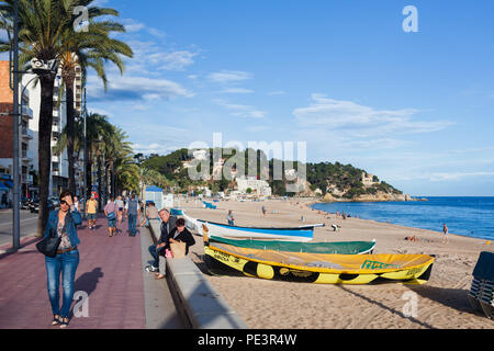 Lloret de Mar resort cittadina sulla Costa Brava in Catalogna, Spagna, persone sul lungomare fiancheggiata da palme, barche su una spiaggia sul Mar Mediterraneo Foto Stock