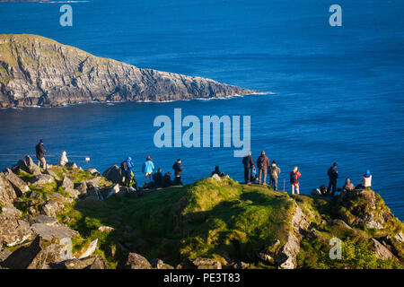 Un gruppo di birdwatcher sono guardando l'atlantico pulcinelle di mare e il bel paesaggio presso l'isola Runde, costa atlantica occidentale, Norvegia. Foto Stock