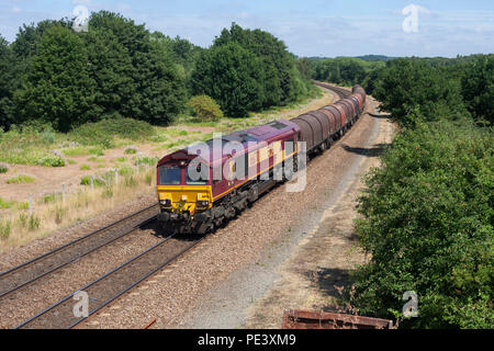 Un DB Cargo classe 66 locomotiva alla vecchia Denaby (est di Mexborough, South Yorkshire) con un treno merci acciaio trasporto in carri coperti Foto Stock