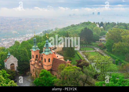 Prague Petrin Hill, veduta aerea della chiesa di San Lorenzo a Petrin Hill visto contro lo sfondo della Nebbia avvolta Nove Mesto district, Praga. Foto Stock