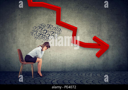 Premuto business donna guardando in giù a caduta della freccia rossa sentirsi confuso ha molte domande. Caduta e concetto di ammortamento. Foto Stock