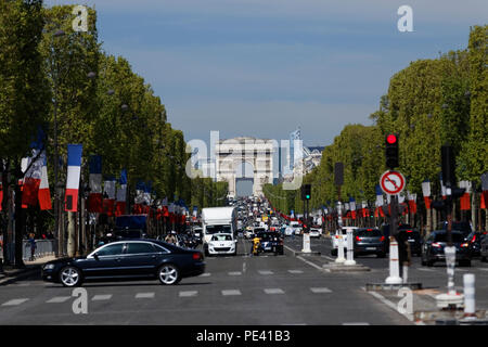 Unità di traffico lungo gli Champs Elysees con l'Arc de Triomphe. Il Champs Elysees è la più famosa strada di Parigi. Foto Stock