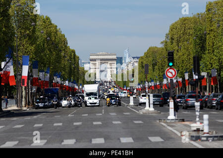 Unità di traffico lungo gli Champs Elysees con l'Arc de Triomphe. Il Champs Elysees è la più famosa strada di Parigi. Foto Stock