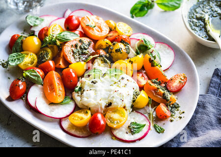 Burrata con colorati di pomodori ciliegini insalata con Pesto di fatti in casa Foto Stock