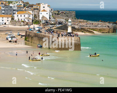 ST IVES, Inghilterra - 19 giugno: turisti essendo presa a mare escursioni in barca su un bel giorno di estate in St Ives, Cornwall. In St Ives, Inghilterra. Sul xix Foto Stock