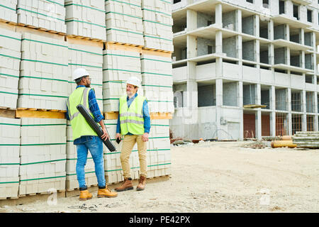 Costruzione Engineers parlando vicino a materiali Foto Stock