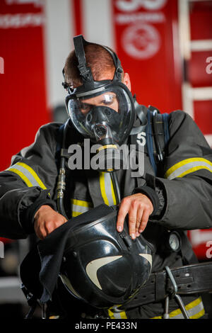 Foto del vigile del fuoco indossando maschera a gas vicino a motore Fire Foto Stock