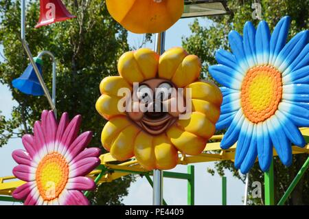 Fiori colorati cartoon in luna park per bambini Foto Stock