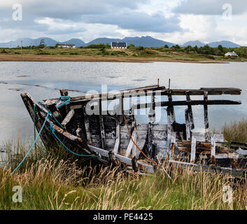 Prua del relitto di una barca con Twelve Ben al di là dell'isola se Inishnee vicino Roundstone sulla costa del Connemara Irlanda Foto Stock