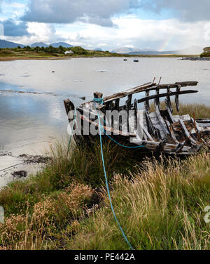 Prua del relitto di una barca con Twelve Ben al di là dell'isola se Inishnee vicino Roundstone sulla costa del Connemara Irlanda Foto Stock