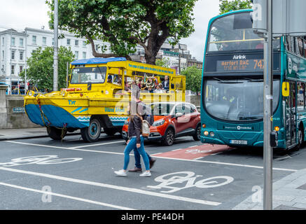 Il Duck Tours veicolo anfibio in attesa in corrispondenza di un passaggio pedonale con un automobile e bus nel centro di Dublino in Irlanda Foto Stock