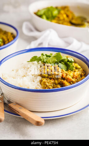 Curry di lenticchie con riso, cucina Indiana, tarka dal, sfondo bianco. Cibo vegan. Pulire il concetto di mangiare. Foto Stock