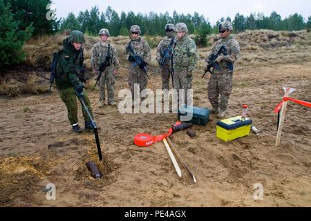 Il lituano Forze terrestri Cpl. Nerijus Zvalionis, nativo di Kedainiai ed esplosivo ordinanza esperto di smaltimento assegnato all'Juozas ingegnere Vitkus battaglione, dimostra come utilizzare un dragamine chiamato "marmotta" per individuare un guscio inesplose NEGLI STATI UNITI. Paracadutisti dell'esercito assegnato alla società di cane, 1° Battaglione, 503rd Reggimento di Fanteria, 173rd Brigata Aerea, durante l'esercizio fisico e ingegnere Thunder 2015 tenutosi presso il Grande Hetman lituano Radvila Jonusas reggimento di formazione, in Rukla, Lituania, Sett. 9, 2015. I soldati del 173rd Brigata Aerea sono parte di Operazione Atlantic risolvere, un ongo Foto Stock