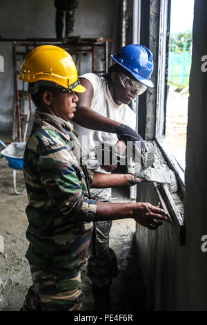 Stati Uniti Louisiana National Guard PFC. Chynna Williams, destra, da ingegnere 1022nd Company, stabilisce lo stucco con l'assistenza di Tentera Darat Malaysia dal 2° Squadrone tecnico reale reggimento durante una scuola costruire al di là di funzionamento Keris sciopero, Pacific Pathways 2015 in Tai Ping, Malaysia, sul Sett. 9, 2015. Funzionamento Keris Strike è una pianificata regolarmente esercizio bilaterale sponsorizzato da U.S. Army-Pacific, ospitato annualmente dal Tentera Darat Malaysia a promuovere la sicurezza regionale, il sostegno e la cooperazione. (U.S. Esercito Foto di Spc. Michael Sharp/rilasciato) Foto Stock