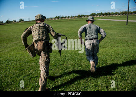 Chief Warrant Officer due Andy Knote, a nord di Chicago e di Master Sgt. Lancia Espinosa, di Skandia, Mich, U.S. La riserva di esercito di lotta internazionale team concorrenti, rush 100 metri per una cottura berm all'inizio di un di 7 chilometro di fucile militare match di biathlon con la partecipazione di vari ostacoli fisici durante il 2015 Forze armate canadesi piccole armi concentrazione al Connaught gamma al di fuori di Ottawa, Canada, Sett. 14. La precisione di tiro internazionale di concorrenza durato circa due settimane, portando in più di 250 totale concorrenti da inglesi, canadesi e statunitensi le forze armate a competere in più Foto Stock