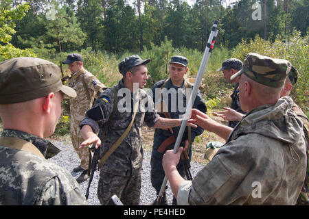 Un soldato con la nazionale ucraina di guardia xxi brigata mutandine suoi subalterni sulla corretta perforazione di una cablata-ostacolo durante il primo giorno di intrepida custode della terza rotazione, Sett. 15, 2015, in Yavoriv, Ucraina. Paracadutisti da parte degli Stati Uniti Dell'esercito 173rd Brigata Aerea sono in Ucraina per la terza rotazione al treno Ucraina la neonata guardia nazionale come parte di intrepida custode, che è programmato per ultimo a novembre. (U.S. Esercito foto di Sgt. Alexander Skripnichuk, xiii Affari pubblici distacco) Foto Stock