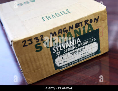 Un magnetron a cavità dell'era della seconda guerra mondiale, ancora nella sua confezione originale, fungeva da trasmettitore radar ad alta potenza. Questo dispositivo ha consentito il rilevamento preciso di piccoli bersagli, influenzando significativamente la progettazione radar per aeromobili e navi navali. Gli scienziati britannici sotto Sir Henry Tizard hanno collaborato con i team del Naval Research Laboratory degli Stati Uniti guidati dal Rear Adm. Harold Bowen per implementare questa tecnologia, ponendo le basi per sistemi radar avanzati e moderne capacità di guerra elettronica utilizzate nell'aviazione e nella difesa marittima. Foto Stock
