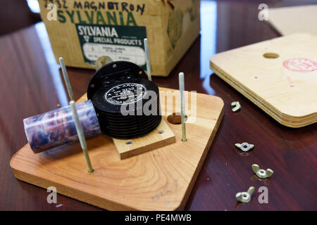 L'unboxing di un magnetron a cavità dell'era della seconda guerra mondiale dimostra la sua funzione di trasmettitore radar ad alta potenza, cruciale per il rilevamento di piccoli bersagli in aerei e navi navali. Sviluppato da esperti britannici guidati da Sir Henry Tizard in collaborazione con gli scienziati del Naval Research Laboratory sotto la guida di Harold Bowen, questo dispositivo ha influenzato significativamente la progettazione radar, stabilendo standard tecnologici per l'aviazione, la difesa marittima e i sistemi di guerra elettronica. Foto Stock