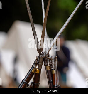 Rifled Musket dalla guerra civile americana volte appoggiato su uno un altro incrocio in verticale con la silhouette di un irriconoscibile US Army soldier reen Foto Stock