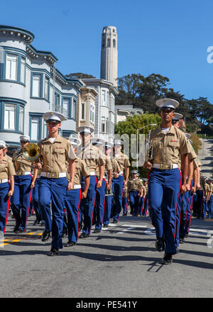 Marines con la prima divisione Marine Band Marzo oltre la Torre Coit durante il patrimonio italiano parata del 11 ottobre., come parte di San Francisco Fleet Week 2015. SFFW '15 è un evento della durata di una settimana che unisce un esclusivo programma di training e formazione, riunendo le principali civile soccorritori di emergenza e di crisi navale di forze di risposta di scambio di migliori pratiche in materia di aiuto umanitario aiuto in caso di catastrofe con particolare enfasi sulla difesa sostegno alle autorità civili. Foto Stock