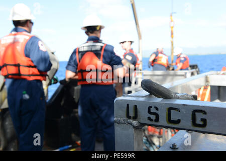 Costa guardie preparare per condurre una evoluzione di formazione per assemblare, implementare e far funzionare una nave di opportunità la scrematura del sistema a bordo del rimorchiatore Na'ina al di fuori del Porto di Honolulu e Oahu, Sett. 30, 2015. La Voss è un portatile di side-skimming olio-sistema di recupero, che può essere distribuito da la maggior parte del lavoro le navi di oltre 65 metri di lunghezza. (U.S. Coast Guard foto di Sottufficiali di 2a classe di Tara Molle/rilasciato) Foto Stock