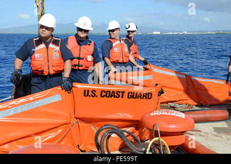 Costa guardie preparare per condurre una evoluzione di formazione per assemblare, implementare e far funzionare una nave di opportunità la scrematura del sistema a bordo del rimorchiatore Na'ina al di fuori del Porto di Honolulu e Oahu, Sett. 30, 2015. La Voss è un portatile di side-skimming olio-sistema di recupero, che può essere distribuito da la maggior parte del lavoro le navi di oltre 65 metri di lunghezza. (U.S. Coast Guard foto di Sottufficiali di 2a classe di Tara Molle/rilasciato) Foto Stock