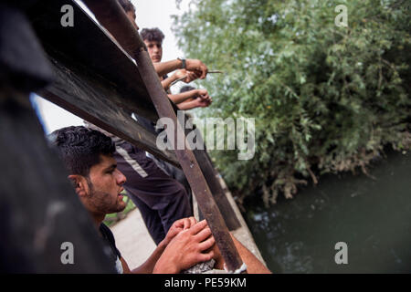 I rifugiati si vede la pesca nel fiume accanto al campo. Profughi che tentano di fare il loro modo nell'Unione europea attraverso la Bosnia vivono qui in Velika Kladusa nel terribile e in condizioni inumane in una tenda in città dopo la chiusura dell'ex rotta balcanica, tende improvvisate sono per la maggior parte solo tetto per uomo, donna e bambini. Le persone tentano di attraversare la frontiera attraverso il cosiddetto 'Jungle", ma dopo aver inserito la Croazia vengono picchiati dalla polizia, telefoni sono schiacciati e spesso il denaro è anche tenuto lontano. Dopo che i rifugiati sono spinti indietro alla Bosnia. Foto Stock