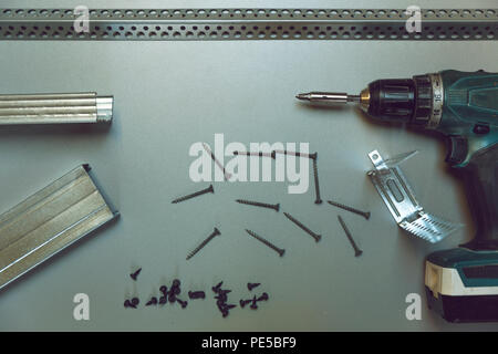 Strumenti di lavoro per il profilo del telaio metallico di montaggio. I profili metallici, cacciavite automatico e le viti. I pannelli in gesso cartonato e installazione di isolamento Foto Stock