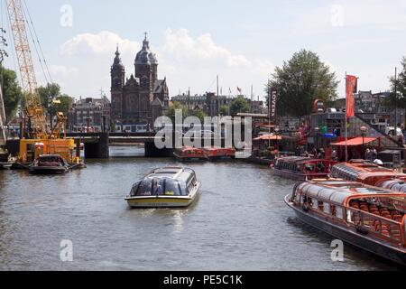 Numerose imbarcazioni turistiche sul fiume IJ nel centro di Amsterdam, Paesi Bassi Foto Stock