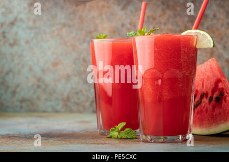 Anguria slushie con calce, estate una bevanda rinfrescante in bicchieri alti su un blu sfondo arrugginito. con spazio di copia Foto Stock