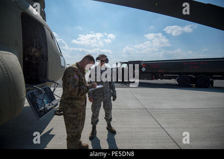 Stati Uniti Il personale dell'esercito Sgt. Jason Tabansky, con 1-214 Supporto generale del battaglione di aviazione, XII Combattere la Brigata Aerea, indicazioni per il JP-8 Il suo combustibile CH-47F elicottero Chinook ricevuti dalla U.S. Air Force Tech. Sgt. Marcus Romero, con 424Air Base Squadron in Wingene, Belgio, Sett. 11, 2015. (U.S. Esercito foto di Visual Information Specialist Pierre-Etienne Courtejoie/rilasciato) Foto Stock